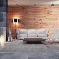 Sitzecke mit weißer Couch und Liegestuhl-ähnlicher Sitzgelegenheit vor einer holzverkleideten Wand