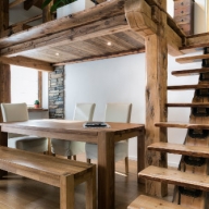 Zimmerausschnitt mit Hochebene inkl. Holztreppe sowie darunter stehendem Holztisch mit Sitzbank aus Eichenholz