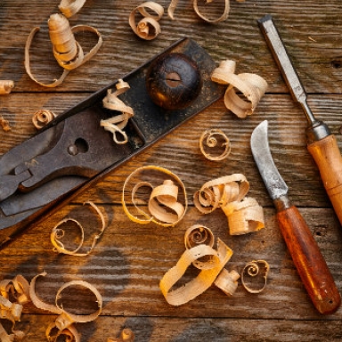 Detailaufnahme von 3 verschiedenen Tischler-Werkzeugen zwischen Holzspäne