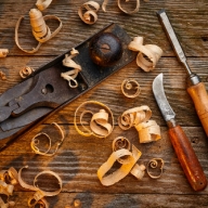 Detailaufnahme von 3 verschiedenen Tischler-Werkzeugen zwischen Holzspäne