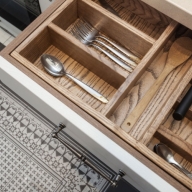 Detailaufnahme aus der Vogelperspektive auf eine geöffnete Besteck-Schublade